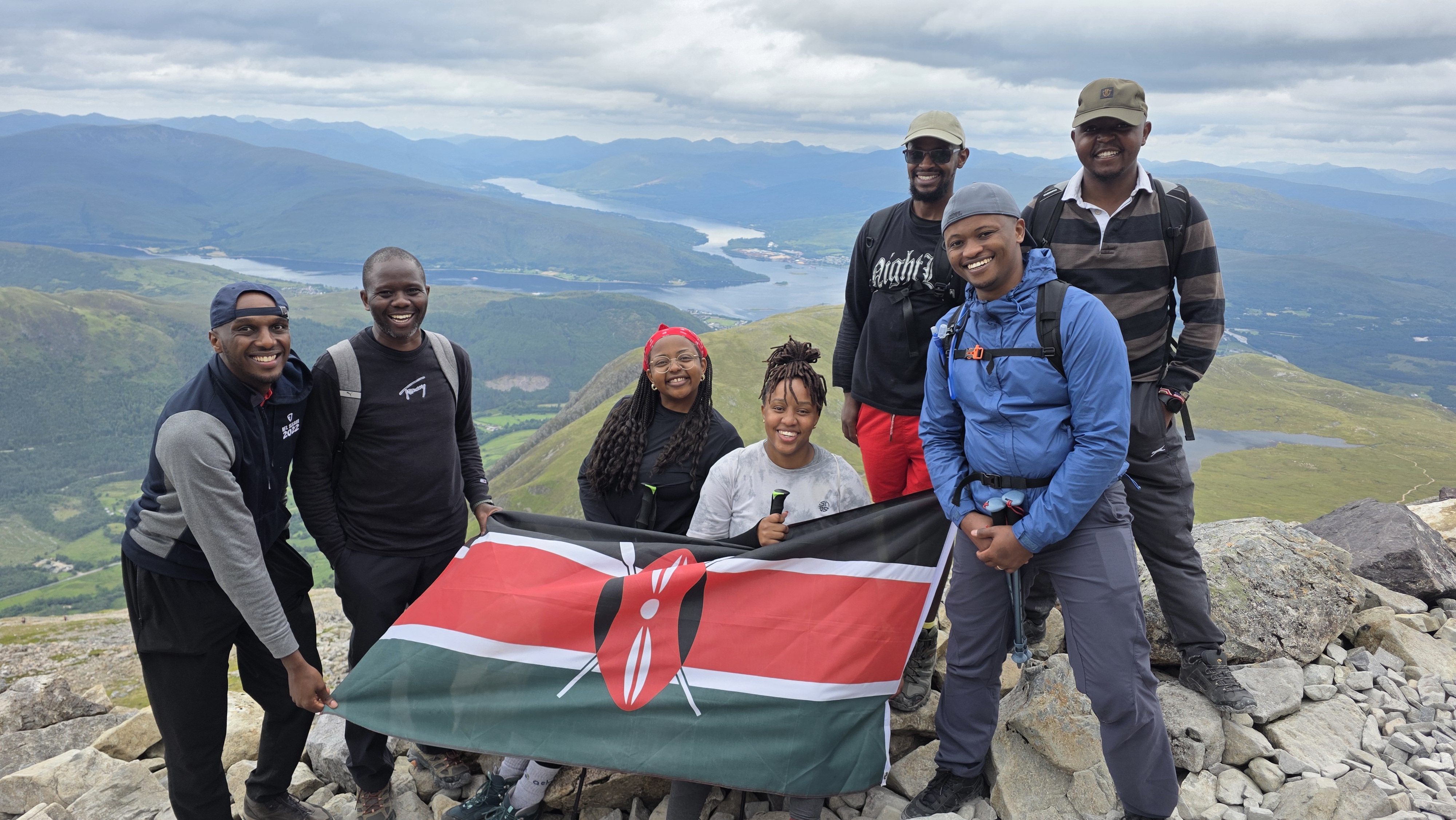 Group proudly holding the Kenyan flag at the summit