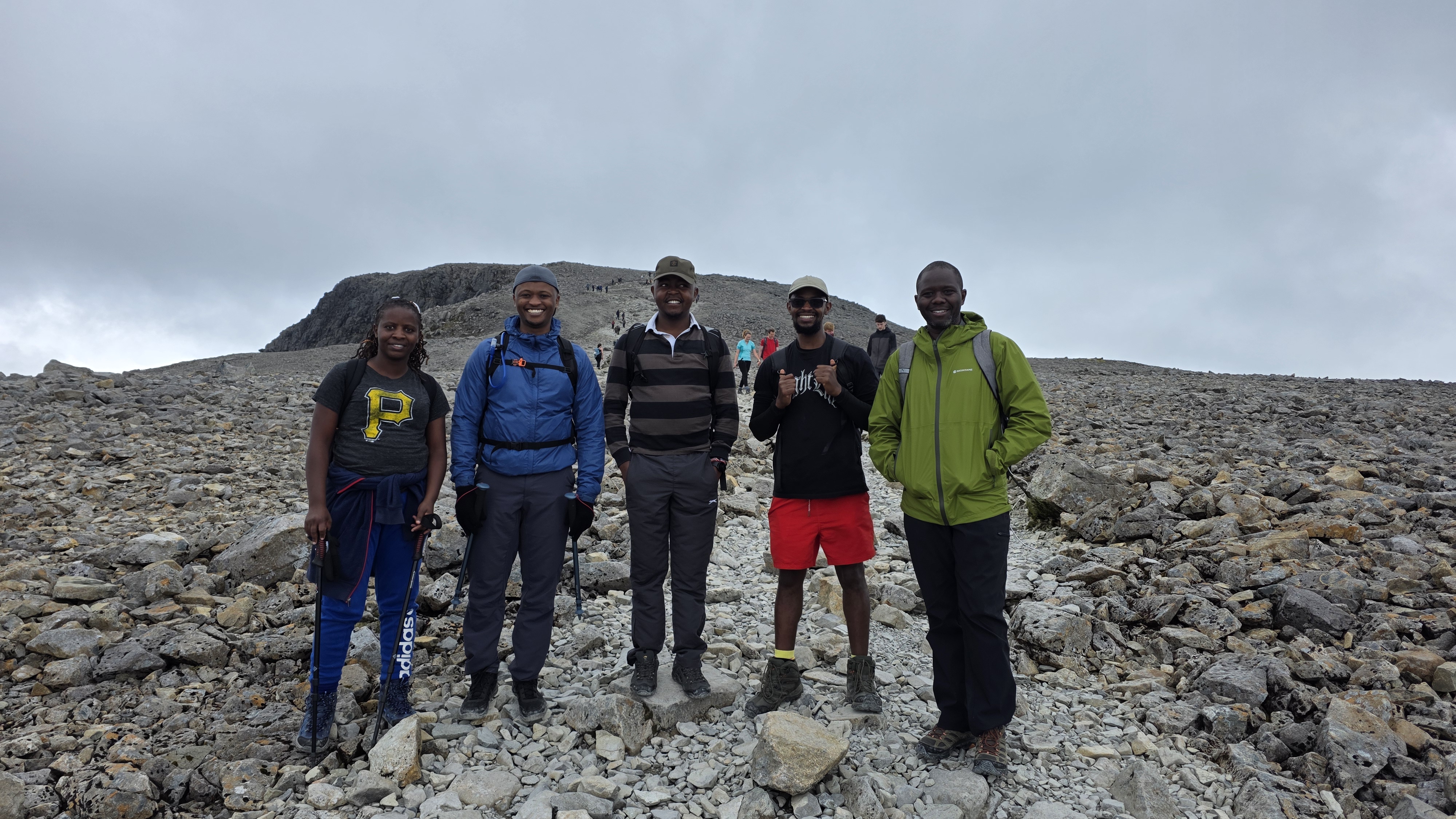Group photo just below the summit, smiles despite the cold mist